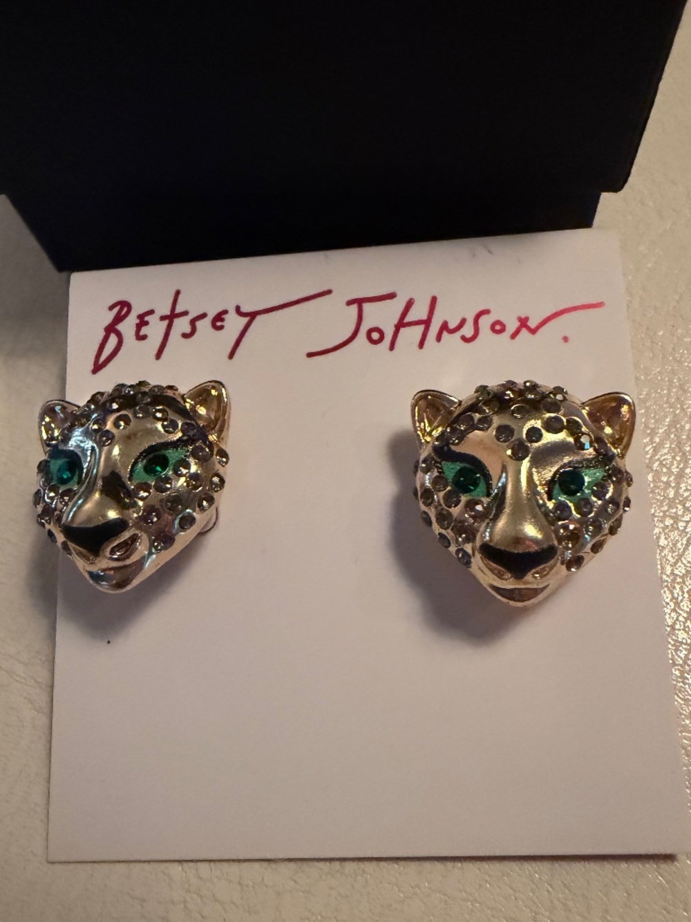 Betsey Johnson gold tone panther earrings with green gem eyes.
